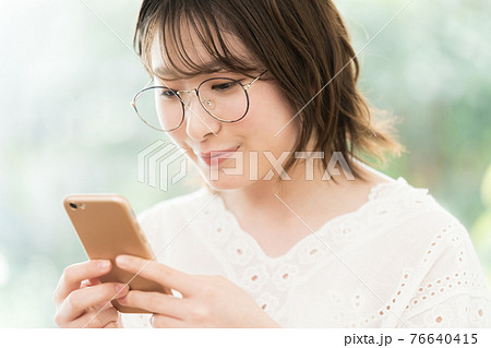 スマートフォンを見る若い女性 76640415