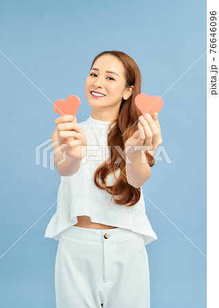 Portrait of nice-looking attractive girl holding in hands two small little heart healthy life lifestyle on blue background Portrait of nice-looking attractive girl holding in hands two small little heart healthy life lifestyle on blue background 76646096