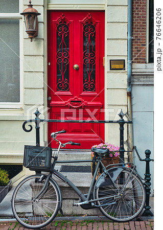 Bicycle near door of old house in Amsterdam street 76646206