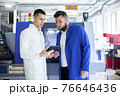 Engineer and technician discussing production process at factory 76646436
