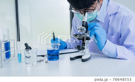 Medical or scientific researcher or man doctor looking at a test tube of clear solution in a laboratory Medical or scientific researcher or man doctor looking at a test tube of clear solution in a laboratory 76648553