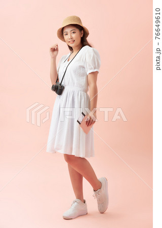 Fun travel portrait of smiling young beautiful Asian tourist woman holding passport isolated on pink background 76649610