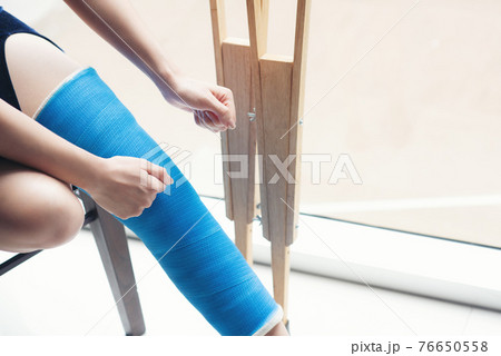 injury woman with leg splint sitting and wooden crutches at hospital injury woman with leg splint sitting and wooden crutches at hospital 76650558