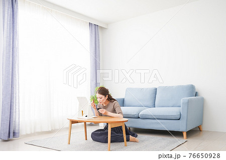 一人暮らしの部屋で化粧をする女性 76650928