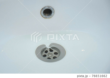 Water is draining in drain hole of the sink in bathroom, closeup view. 76651662