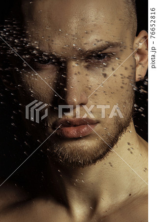 Handsome sport sexy stripped guy portrait in water drops on isolated black background 76652816