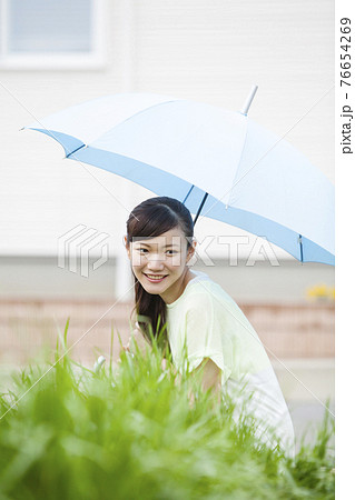傘をさす女性 傘をさす女性 76654269