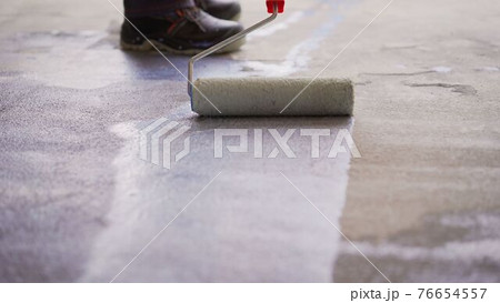 Priming Concrete floor before laying tiles on it, the final preparatory stage for strengthening the surface. Floor priming process. Priming Concrete floor before laying tiles on it, the final preparatory stage for strengthening the surface. Floor priming process. 76654557