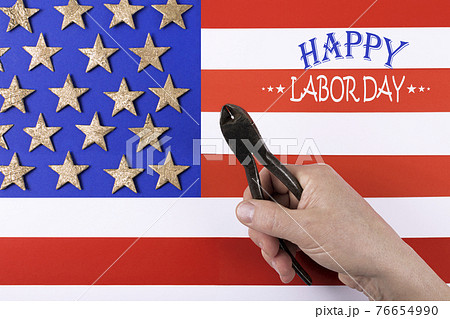 Happy Labor Day. Metal pliers in man's hand. Happy Labor Day. Metal pliers in man's hand. 76654990