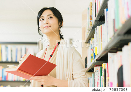 図書館で本を読む若い女性 図書館で本を読む若い女性 76657093
