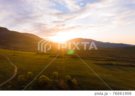 low mountains and pastures in the Carpathian village, landscape at sunset, Ukrainian Carpathians and agricultural fields, trails in the mountains and fields. low mountains and pastures in the Carpathian village, landscape at sunset, Ukrainian Carpathians and agricultural fields, trails in the mountains and fields. 76661906