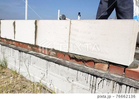 The worker measures the work out wall with a level. The worker measures the work out wall with a level. 76662136