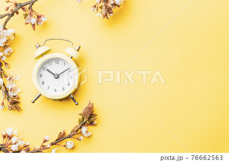 Spring background yellow with flower blossom and April floral nature in beautiful scene with blooming tree, alarm clock . Easter Sunny day. Orchard abstract blurred background. Springtime. 76662563