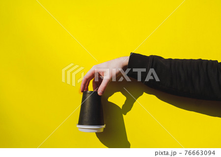 hand holds an upturned paper cup 76663094