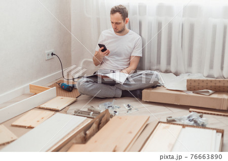 Man looking contacts of help center. Troubles with assembling new furniture, calling for a master. Man looking contacts of help center. Troubles with assembling new furniture, calling for a master. 76663890