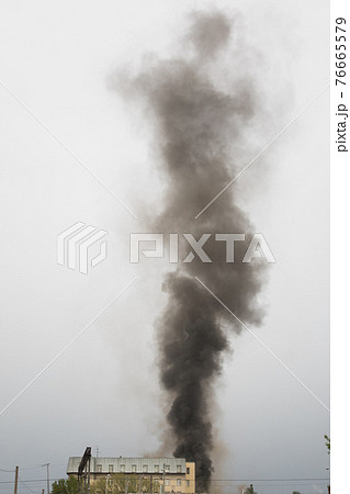 black smoke trail of burning house 76665579
