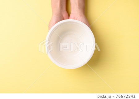Hand holding bowl (Biodegradable, Compostable, Disposable or Eco friendly bowl) on yellow background 76672543