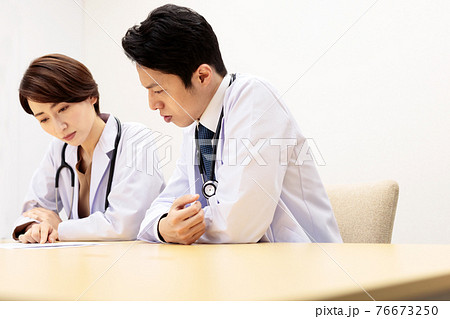 治療方針や医療提供体制について検討する男女の医師 76673250