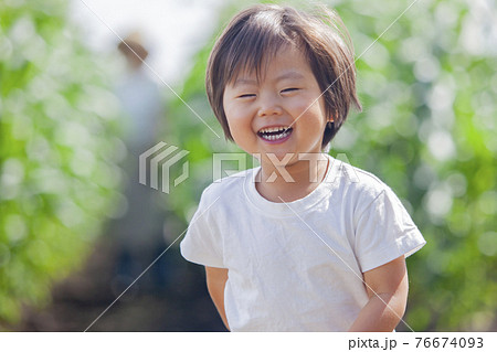 畑で働く農家のお母さんと、畑で遊ぶ子ども 畑で働く農家のお母さんと、畑で遊ぶ子ども 76674093