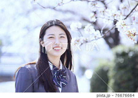 桜と笑顔の女子高生 インスタ風イメージの写真素材