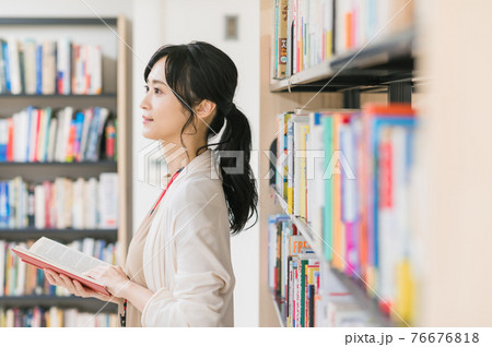 図書館で本を読む若い女性 図書館で本を読む若い女性 76676818