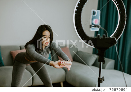 Virtual online fitness. Woman virtual workout at home living room 76679694