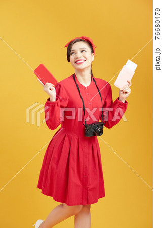 Image of excited young pretty woman tourist posing isolated over yellow wall background holding passport with tickets 76680479