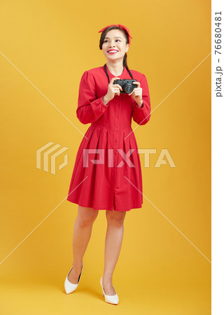 Trendy girl taking pictures with vintage camera 76680481