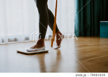 Woman Measuring Body Weight On Weighing Scale At Home. Woman Measuring Body Weight On Weighing Scale At Home. 76681626