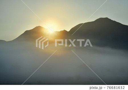 霧の小田代ヶ原と奥日光の山々に日の出 76681632