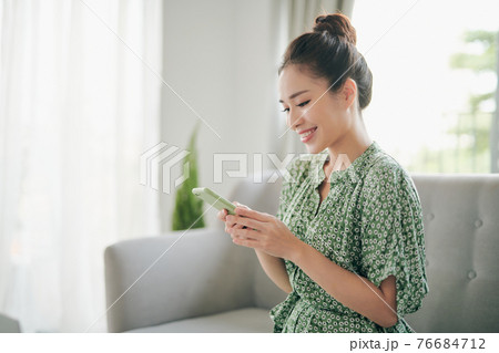 young attractive asian woman to see a smart phone young attractive asian woman to see a smart phone 76684712