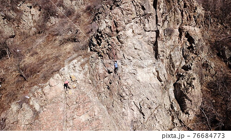 A group of people are engaged in rock climbing. A group of people are engaged in rock climbing. 76684773
