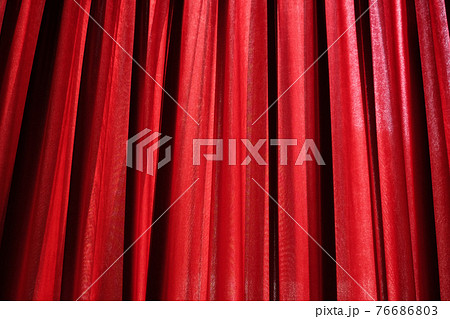 Luxury red closed curtain with light spots in a theater 76686803