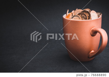 Golden Coins in cups on black background. 76688890