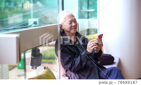 Asian senior man using smartphone outside in public space store happy connecting together 76689187