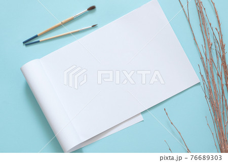 blank a4 paper page with paint brushes on blue background 76689303