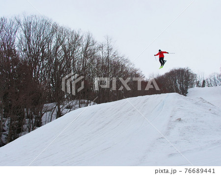 栂池高原スキー場　TG PARKSのキッカーで飛ぶスキーヤー 76689441