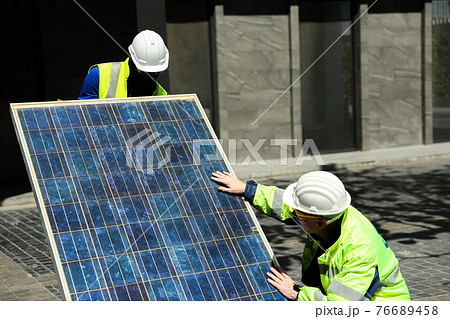 maintenance engineer, Solar energy systems engineer perform analysis solar panels, Portrait of engineer man or worker, people, with solar panels or solar cells on the roof in farm. Power plant with 76689458