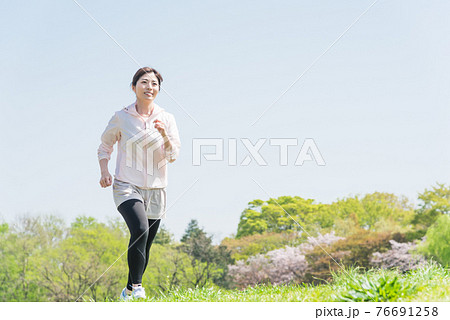 公園でランニングをする女性 公園でランニングをする女性 76691258