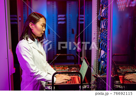 Asian IT specialist performing diagnostic tests 76692115