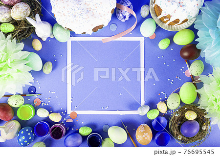 Colorful background with Easter eggs on blue background. Happy Easter concept. Can be used as poster, background, holiday card. Flat lay, top view, copy space. Studio Photo 76695545
