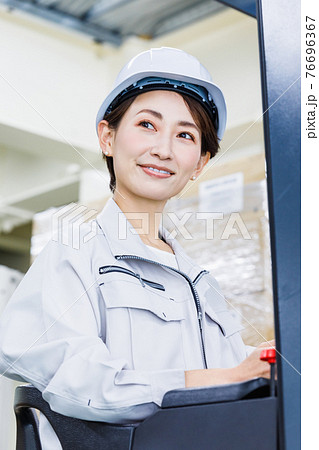 ヘルメットを被りフォークリフトを操作する女性 ヘルメットを被りフォークリフトを操作する女性 76696367