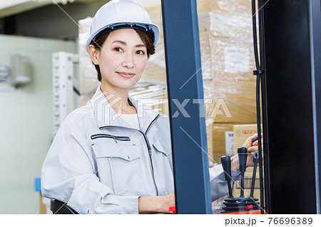 ヘルメットを被りフォークリフトを操作する女性 ヘルメットを被りフォークリフトを操作する女性 76696389