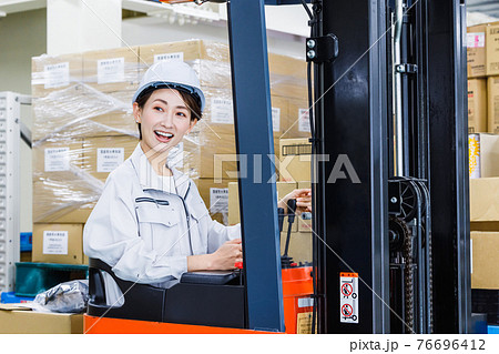 ヘルメットを被りフォークリフトを操作する女性 ヘルメットを被りフォークリフトを操作する女性 76696412
