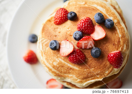 イチゴとブルーベーリーを乗せたホットケーキの写真素材