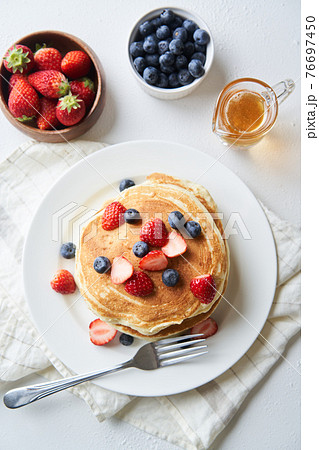 イチゴとブルーベーリーを乗せたホットケーキの写真素材