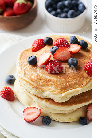 イチゴとブルーベーリーを乗せたホットケーキの写真素材