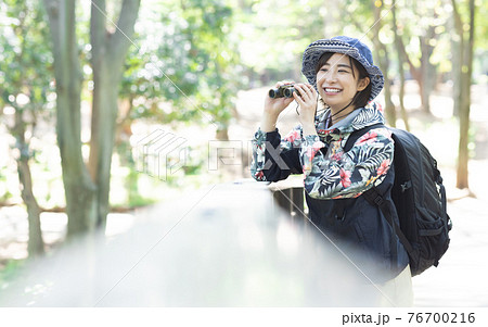 新緑の森でハイキングを楽しむ女性 76700216