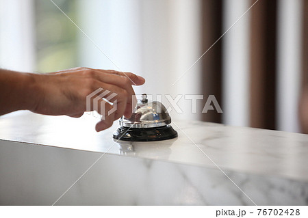 Hotel service bell on a table white glass and simulation hotel background. Concept hotel, travel, room Hotel service bell on a table white glass and simulation hotel background. Concept hotel, travel, room 76702428
