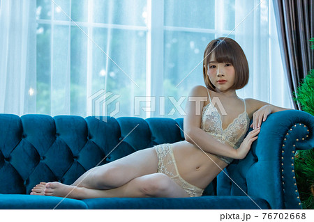 Portrait of young pretty sexy Asian woman wearing white bikini in her room. Portrait of young pretty sexy Asian woman wearing white bikini in her room. 76702668